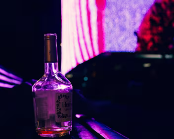 Neon Hangover A forgotten bottle glowing under neon lights - the last trace of a night the city has already moved on from.
