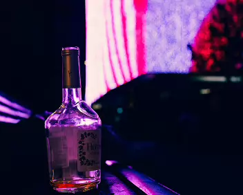 Neon Hangover A forgotten bottle glowing under neon lights - the last trace of a night the city has already moved on from.